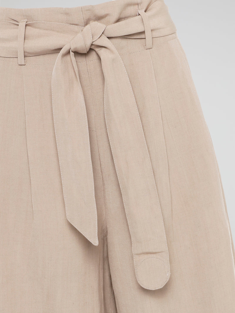 Elevate your style game with these Beige Belted Palazzo Pants from Akris Punto. Crafted with meticulous attention to detail, these pants feature a high-waisted, wide-leg silhouette that flatters every body type. The chic belted waist adds a touch of sophistication, making these pants the perfect choice for a day at the office or a stylish evening event.