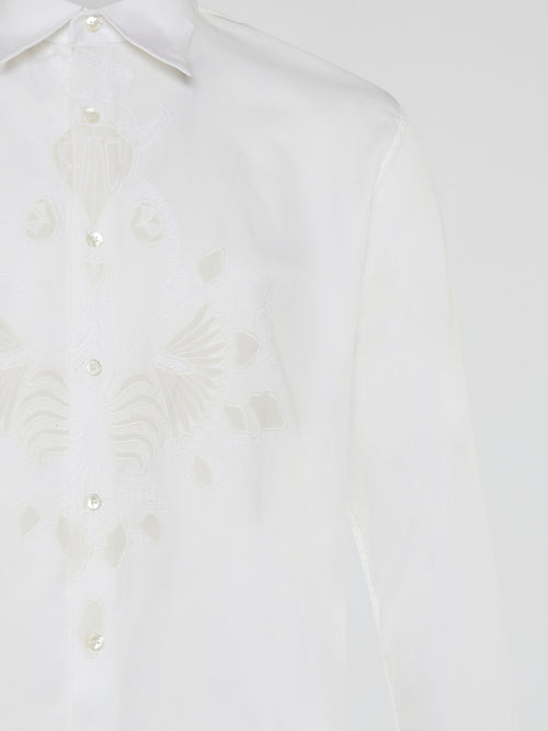 Step into a realm of elegance with the White Embroidered Shirt by Roberto Cavalli, where classic sophistication meets modern charm. Crafted with meticulous attention to detail, this shirt showcases exquisite floral embroidery that dances gracefully across the pristine white fabric. Embrace your inner fashion icon as you effortlessly blend timeless style with a touch of Italian flair, making a statement that is as timeless as it is enchanting.