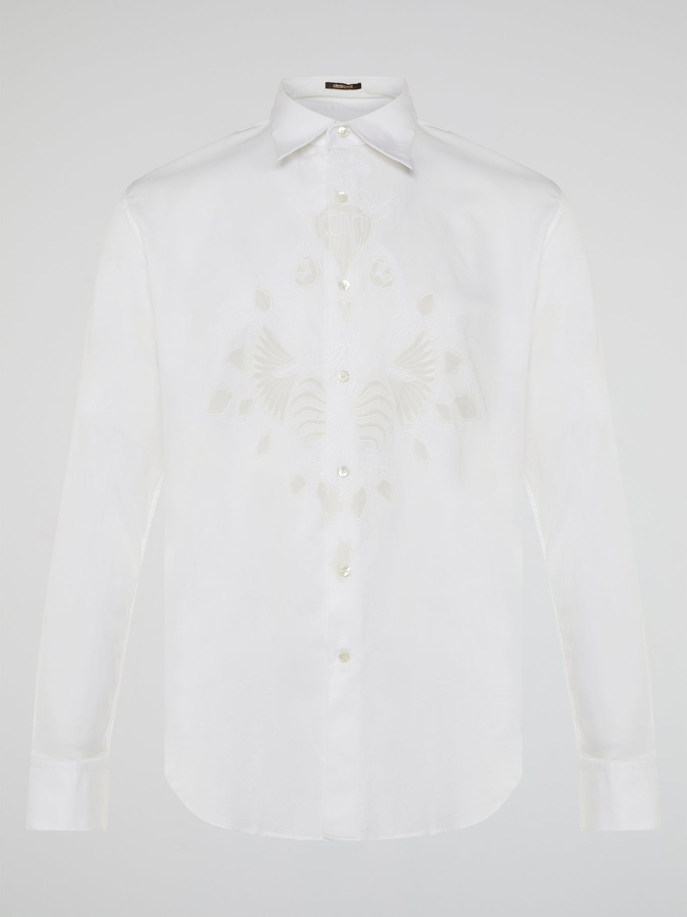 Step into a realm of elegance with the White Embroidered Shirt by Roberto Cavalli, where classic sophistication meets modern charm. Crafted with meticulous attention to detail, this shirt showcases exquisite floral embroidery that dances gracefully across the pristine white fabric. Embrace your inner fashion icon as you effortlessly blend timeless style with a touch of Italian flair, making a statement that is as timeless as it is enchanting.